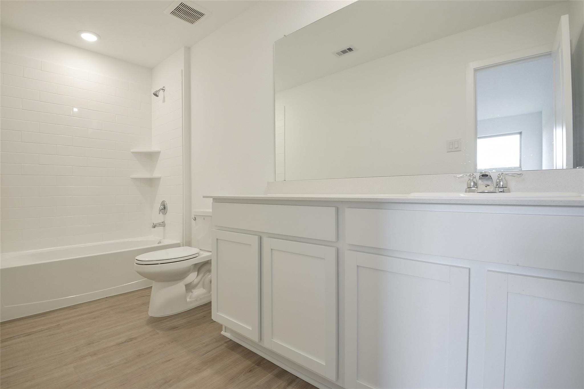 13746 Kit Run Splendora, TX 77372 - Photo 14 of 22 a bathroom with a toilet a sink a mirror and a bathtub