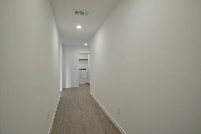 a view of a hallway with wooden floor