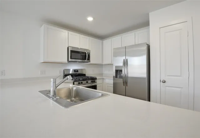 a kitchen with granite countertop a refrigerator and a sink