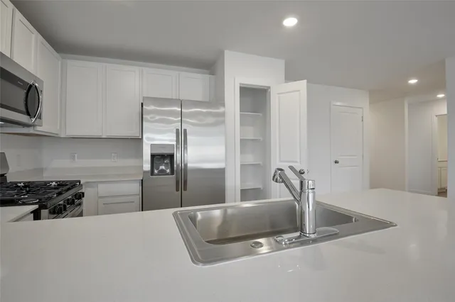 a kitchen with stainless steel appliances granite countertop a refrigerator and a sink