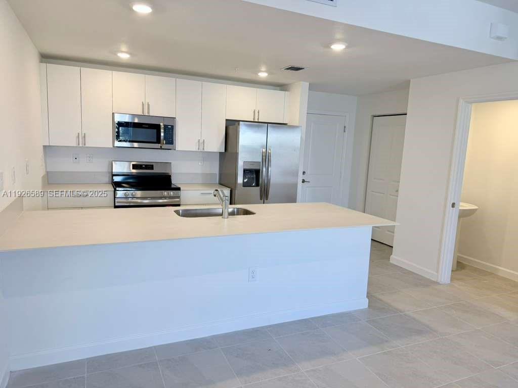 15549 Southwest 280th Street, Unit 6 Homestead, FL 33032 - Photo 3 of 13 a room with kitchen island a sink stainless steel appliances and cabinets