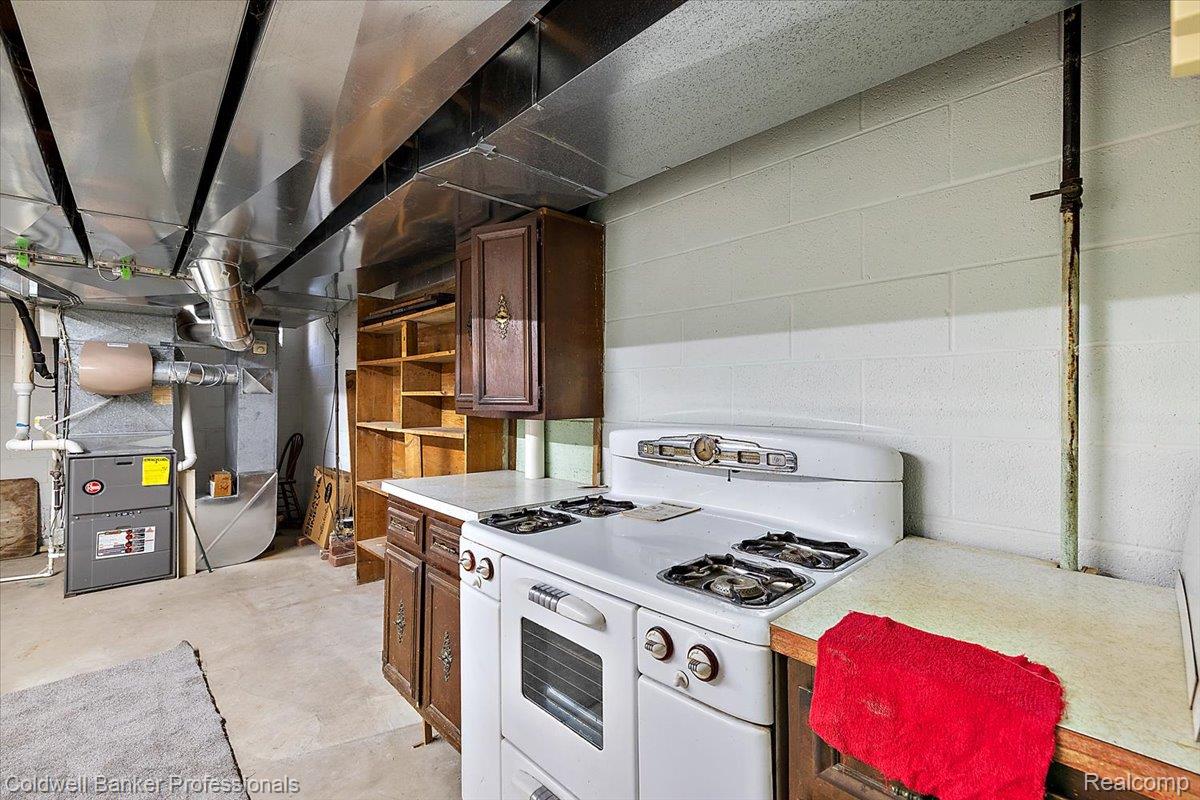 78 Carter Avenue Troy, MI 48098 - Photo 38 of 52 Kitchen featuring white gas range oven, light countertops, open shelves, concrete flooring, and brown cabinets