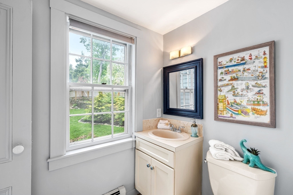 159 Elm Street, Unit 2 Marblehead, MA 01945 - Photo 22 of 34 a bathroom with a granite countertop sink a large mirror a window and a bathtub