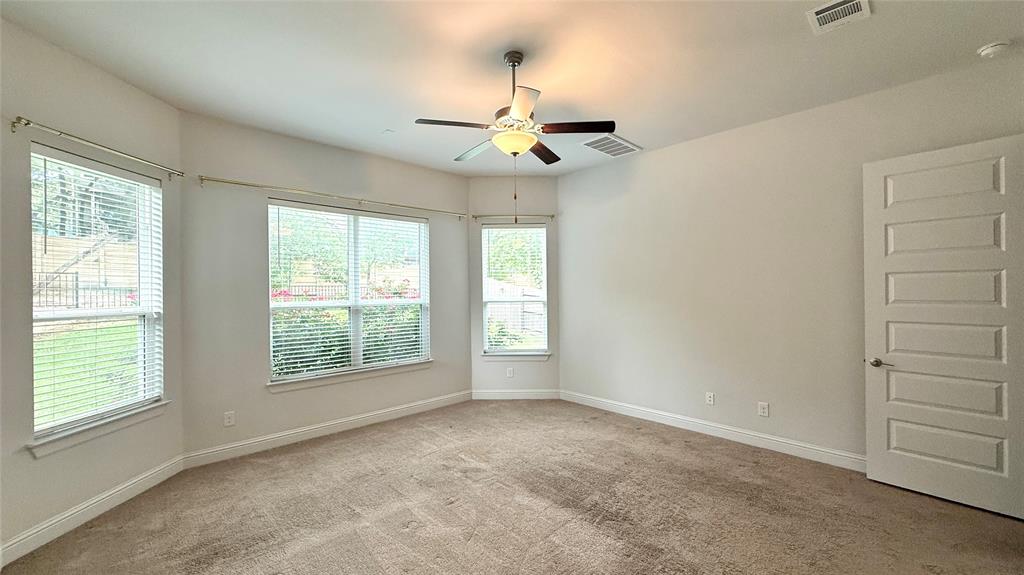 601 C-Bar Ranch Trail, Unit 27 Cedar Park, TX 78613 - Photo 10 of 29 Carpeted room featuring multiple windows with horizontal blinds, a ceiling fan with integrated lighting, and a paneled interior door