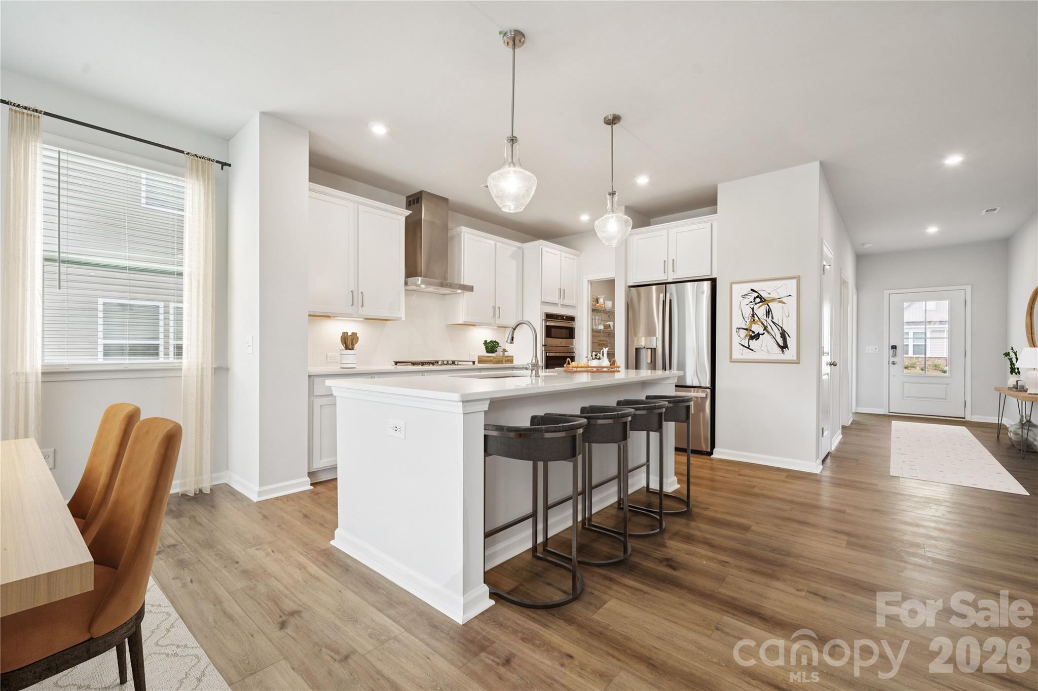 416 Alameda Way Matthews, NC 28104 - Photo 11 of 36 a kitchen with stainless steel appliances granite countertop a stove a sink a dining table and chairs with wooden floor