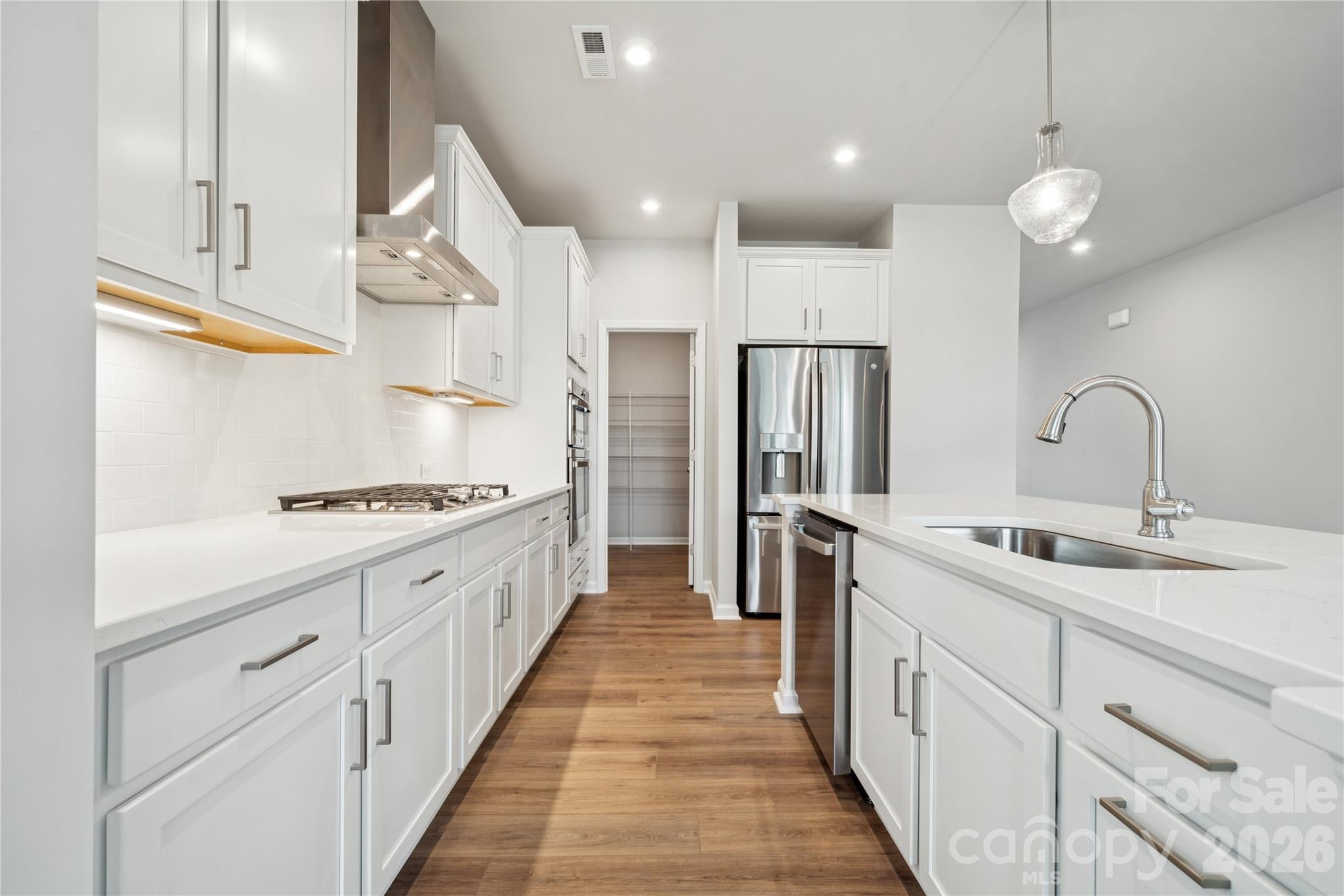416 Alameda Way Matthews, NC 28104 - Photo 12 of 36 a large kitchen with stainless steel appliances a sink stove and refrigerator