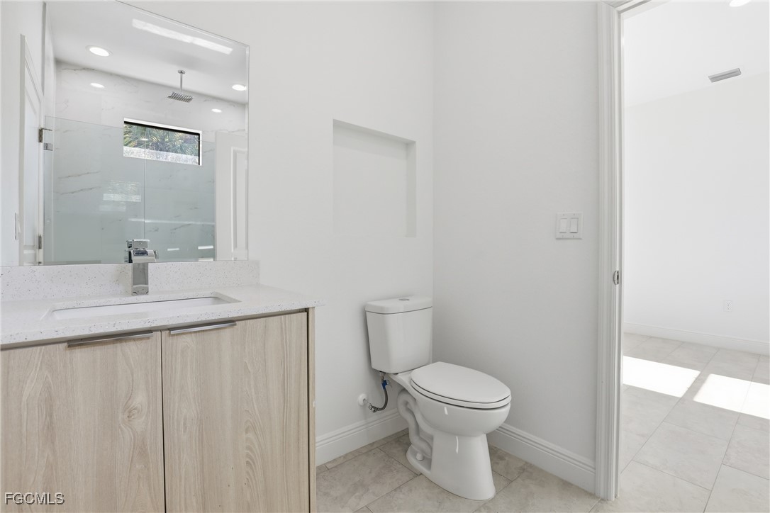 1087 Rugby Circle LaBelle, FL 33935 - Photo 16 of 19 a bathroom with a toilet sink and a mirror