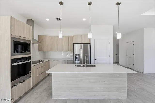 a kitchen with kitchen island a counter top space stainless steel appliances and cabinets