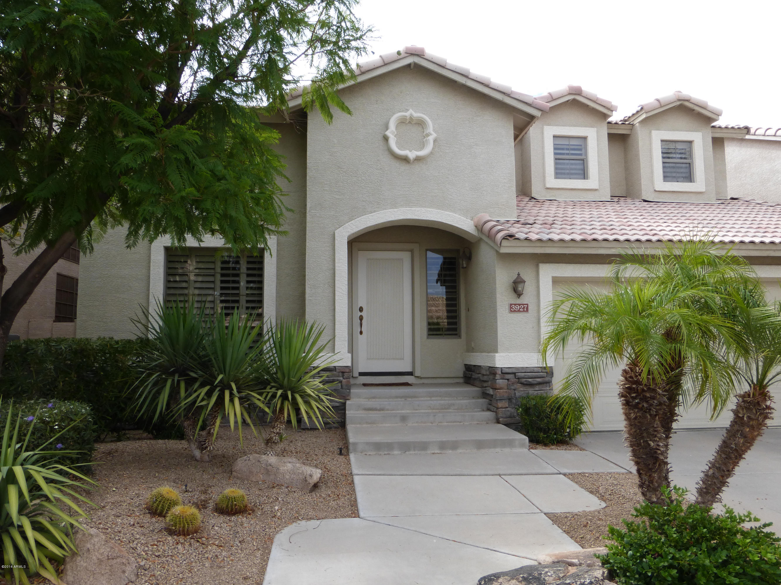 a front view of a house with a garden
