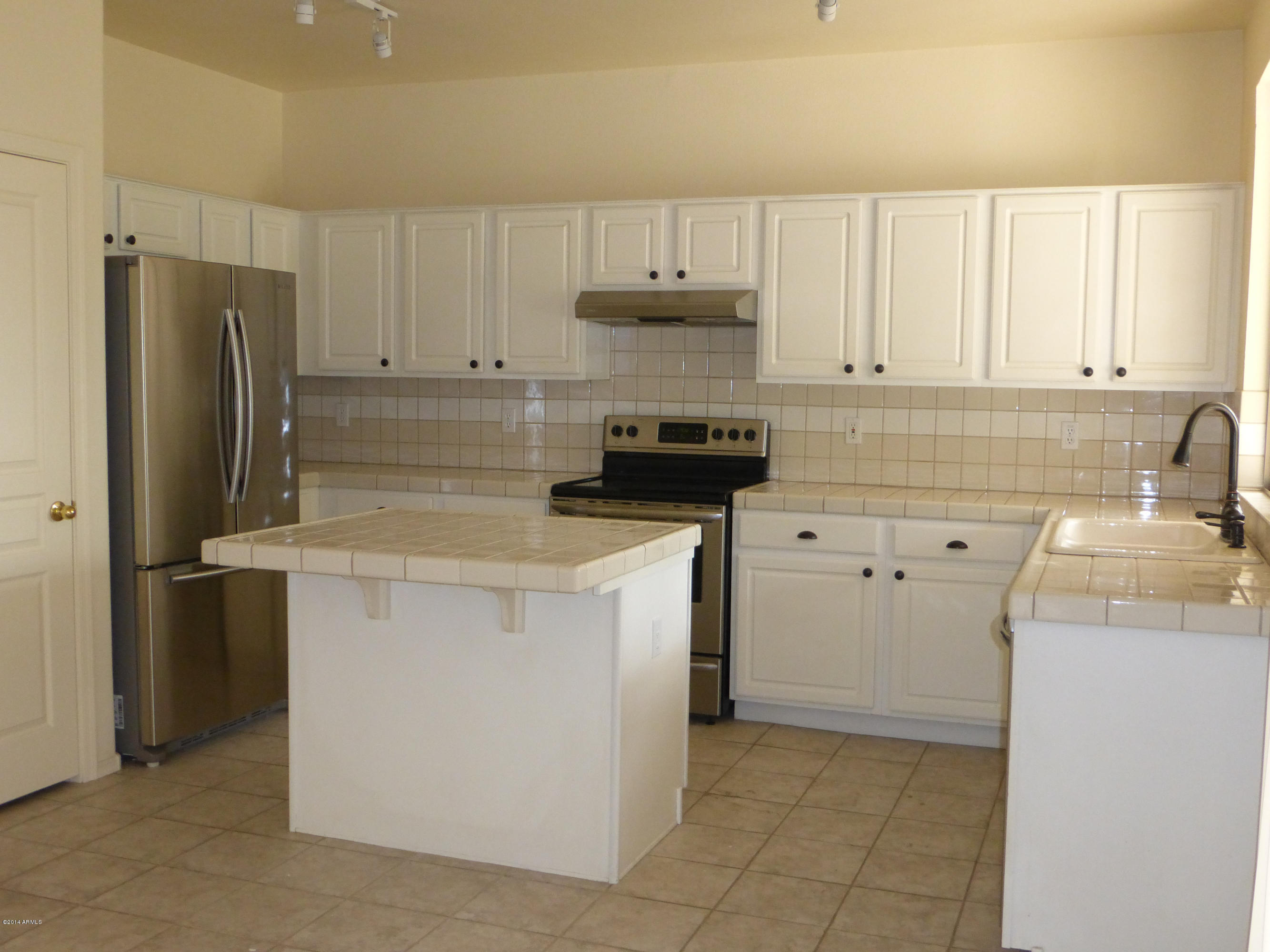 3927 East Agave Road Phoenix, AZ 85044 - Photo 5 of 21 a kitchen with a sink a stove and refrigerator