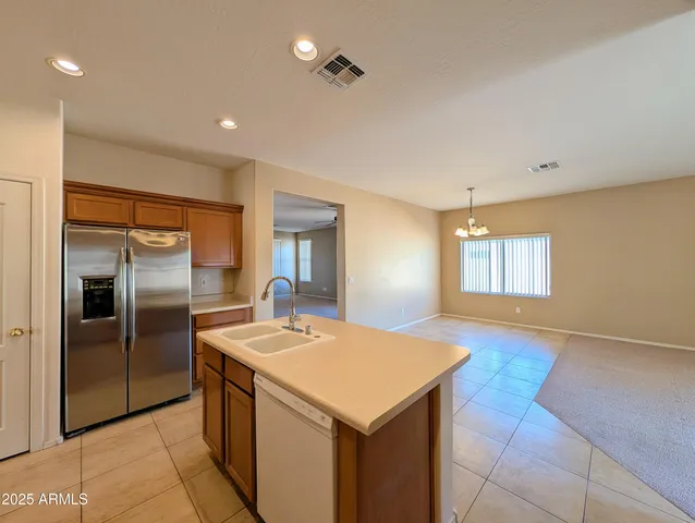 a kitchen with stainless steel appliances a stove top oven a sink and a refrigerator