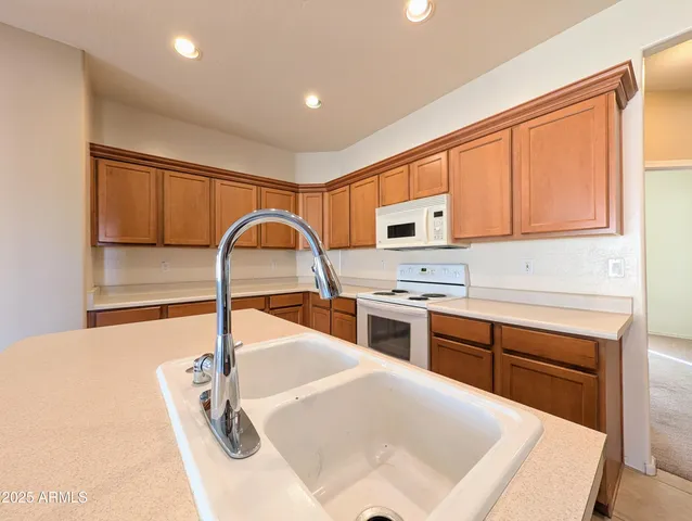 a large kitchen with a refrigerator a stove a microwave and a window