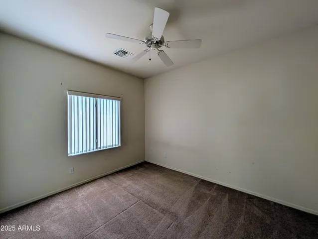an empty room with fan and entrance