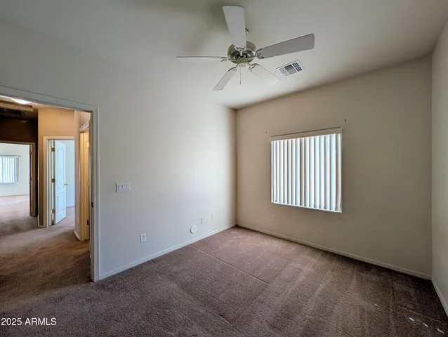 an empty room with a ceiling fan and a window