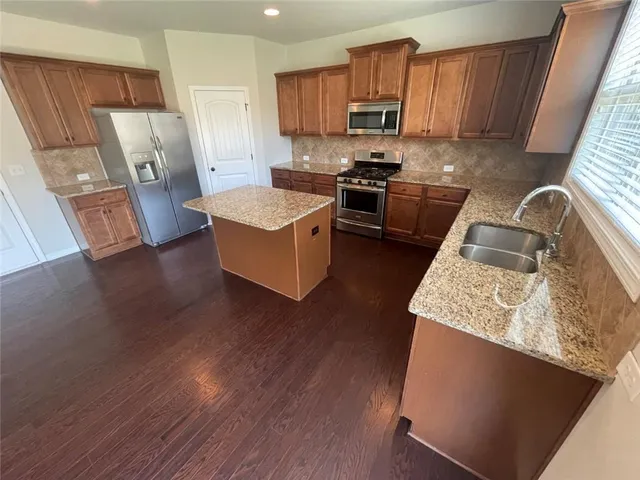 a kitchen with a sink stove and refrigerator