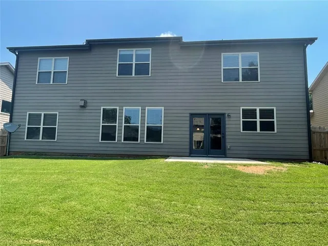 a view of a house with backyard and sitting area