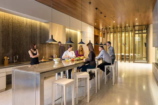 a kitchen with stainless steel appliances kitchen island granite countertop a table and chairs