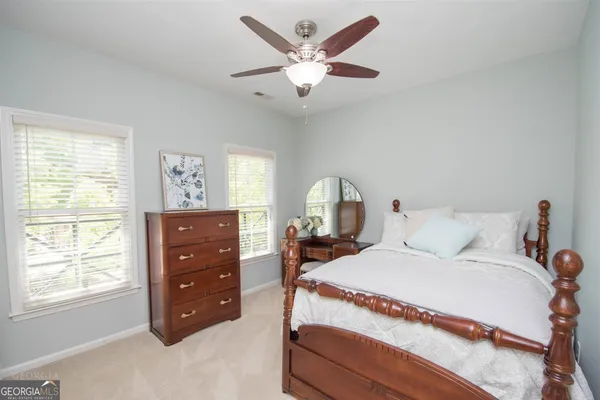 a living room with furniture a flat screen tv and a ceiling fan