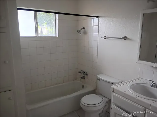 a white toilet sitting next to a bath tub