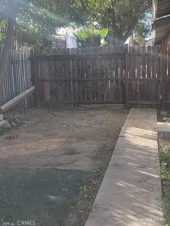 a view of backyard with wooden fence