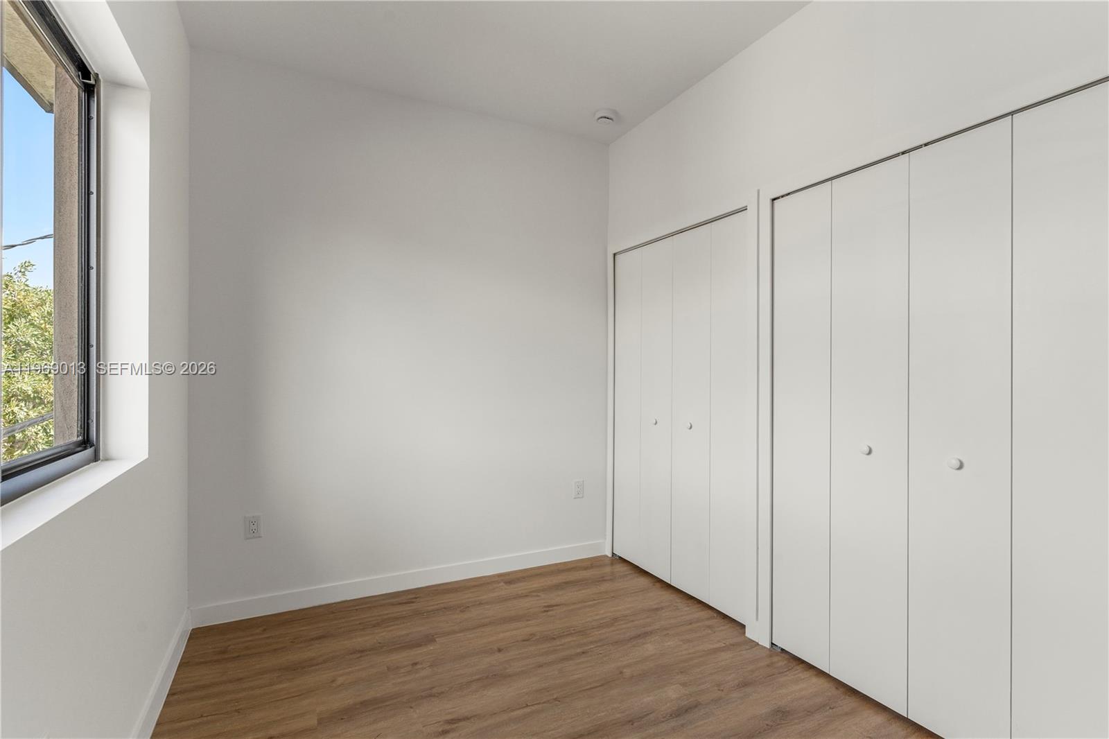 400 Southwest 1st Street, Unit 1 Florida City, FL 33034 - Photo 14 of 28 a view of an empty room with wooden floor and a window