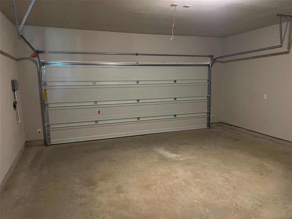 128 Free Stone Drive Georgetown, TX 78628 - Photo 23 of 29 Spacious garage featuring a sectional overhead door, painted walls, concrete flooring, and an exposed garage door opener rail system
