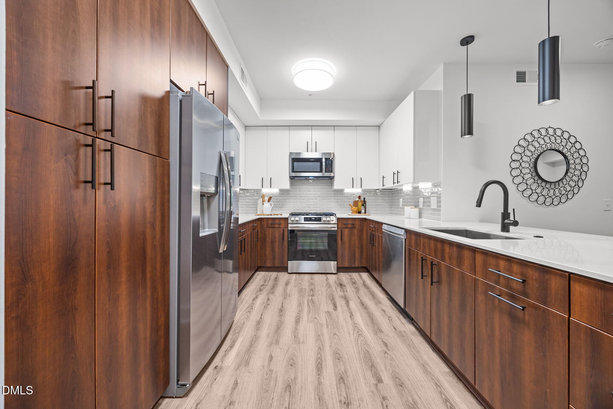 615 West Peace Street, Unit 308 Raleigh, NC 27605 - Photo 3 of 25 a large kitchen with a large counter top a sink stainless steel appliances and cabinets