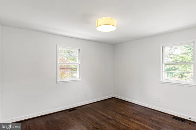 an empty room with wooden floor and a window