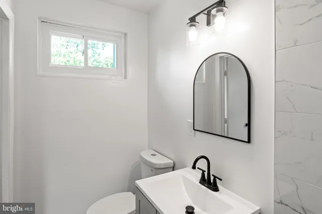a bathroom with a toilet sink and mirror