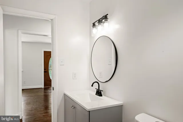 a bathroom with a sink a toilet and a mirror