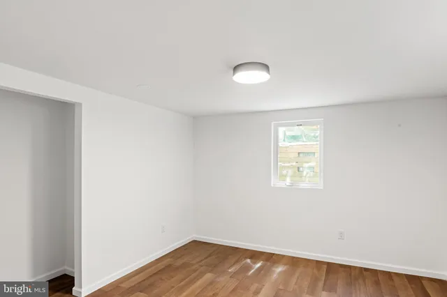 an empty room with wooden floor and closet