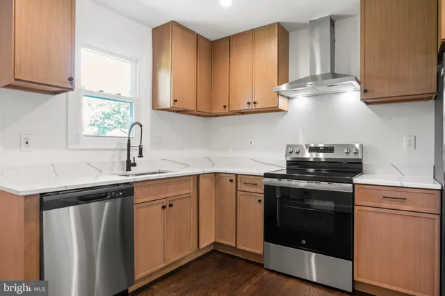 a kitchen with stainless steel appliances granite countertop a sink stove and cabinets
