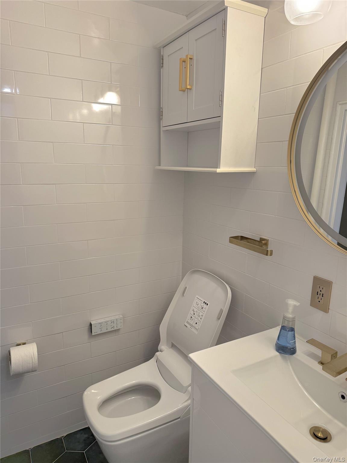 22-27 76th Street, Unit B2 Queens, NY 11370 - Photo 9 of 12 a bathroom with a toilet sink and mirror
