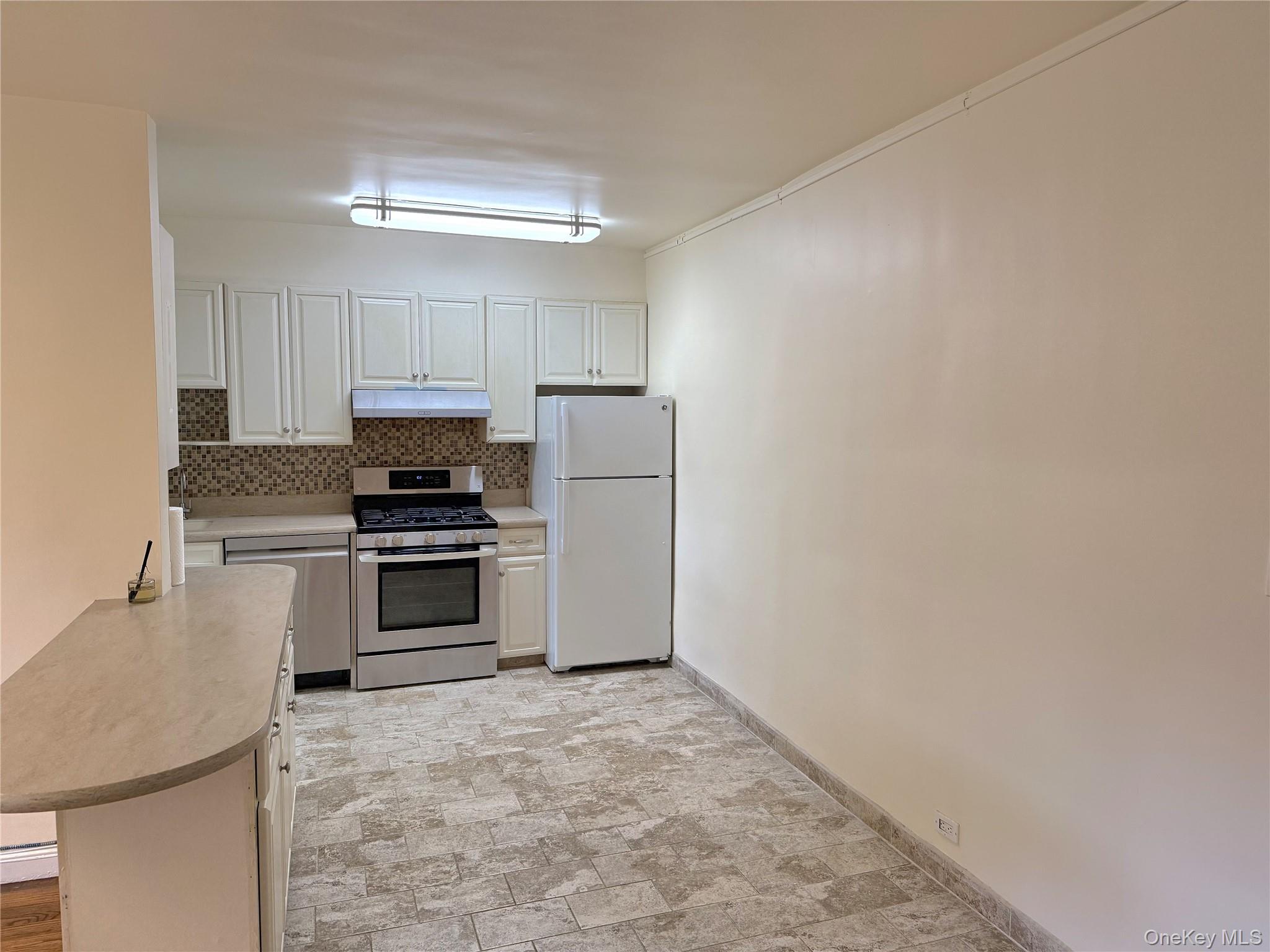 22-27 76th Street, Unit B2 Queens, NY 11370 - Photo 10 of 12 a kitchen with a refrigerator sink and stove top oven