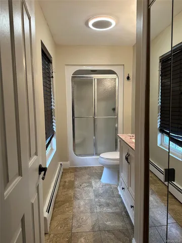 a bathroom with a glass door shower and a sink