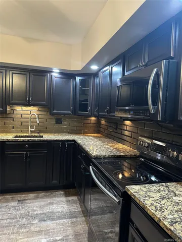 a kitchen with granite countertop stainless steel appliances and cabinets