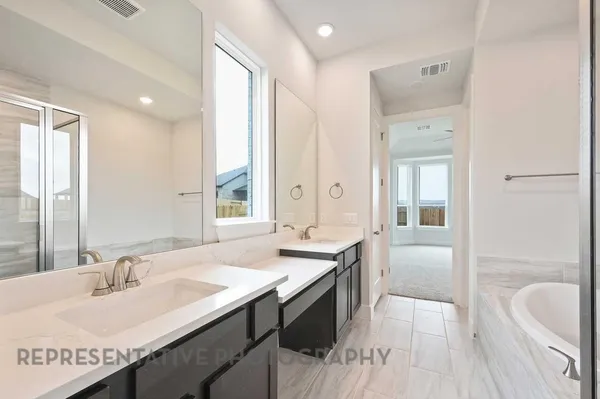 a spacious bathroom with a granite countertop sink a mirror and a bathtub