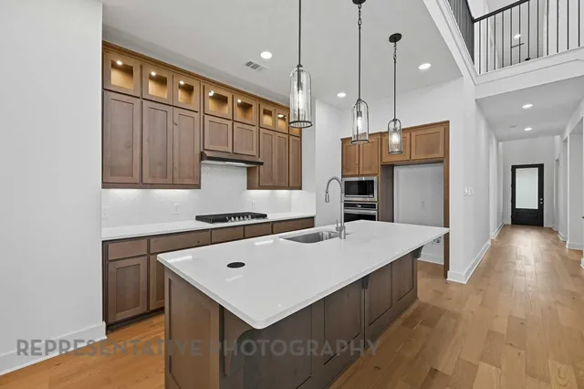 a kitchen that has a kitchen island wooden cabinets and stainless steel appliances