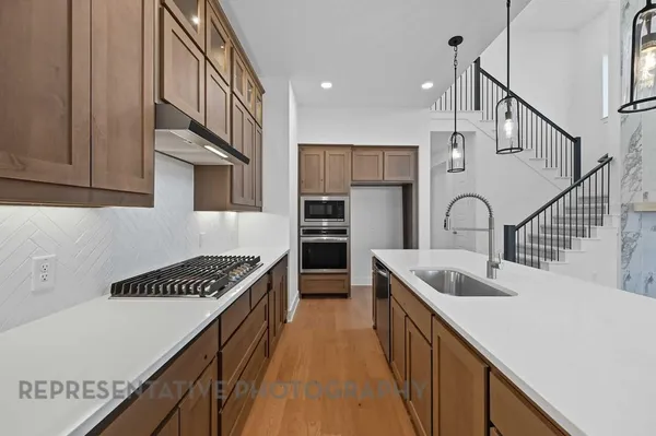 a kitchen with stainless steel appliances granite countertop a sink and stove
