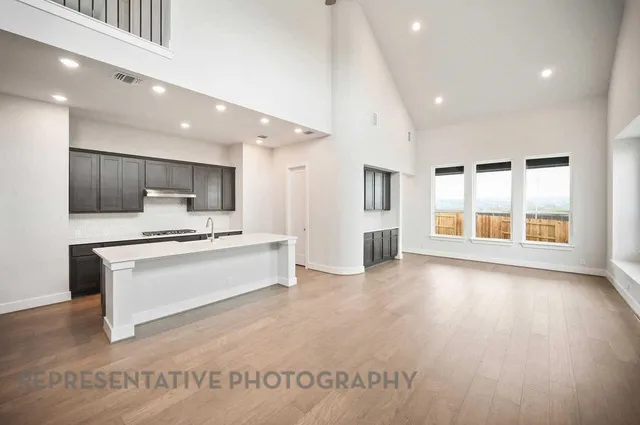 a large white kitchen with a large window and stainless steel appliances