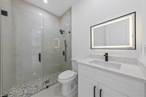 a bathroom with a sink a toilet and shower