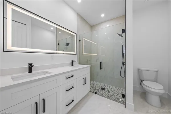 a bathroom with a sink a toilet and shower