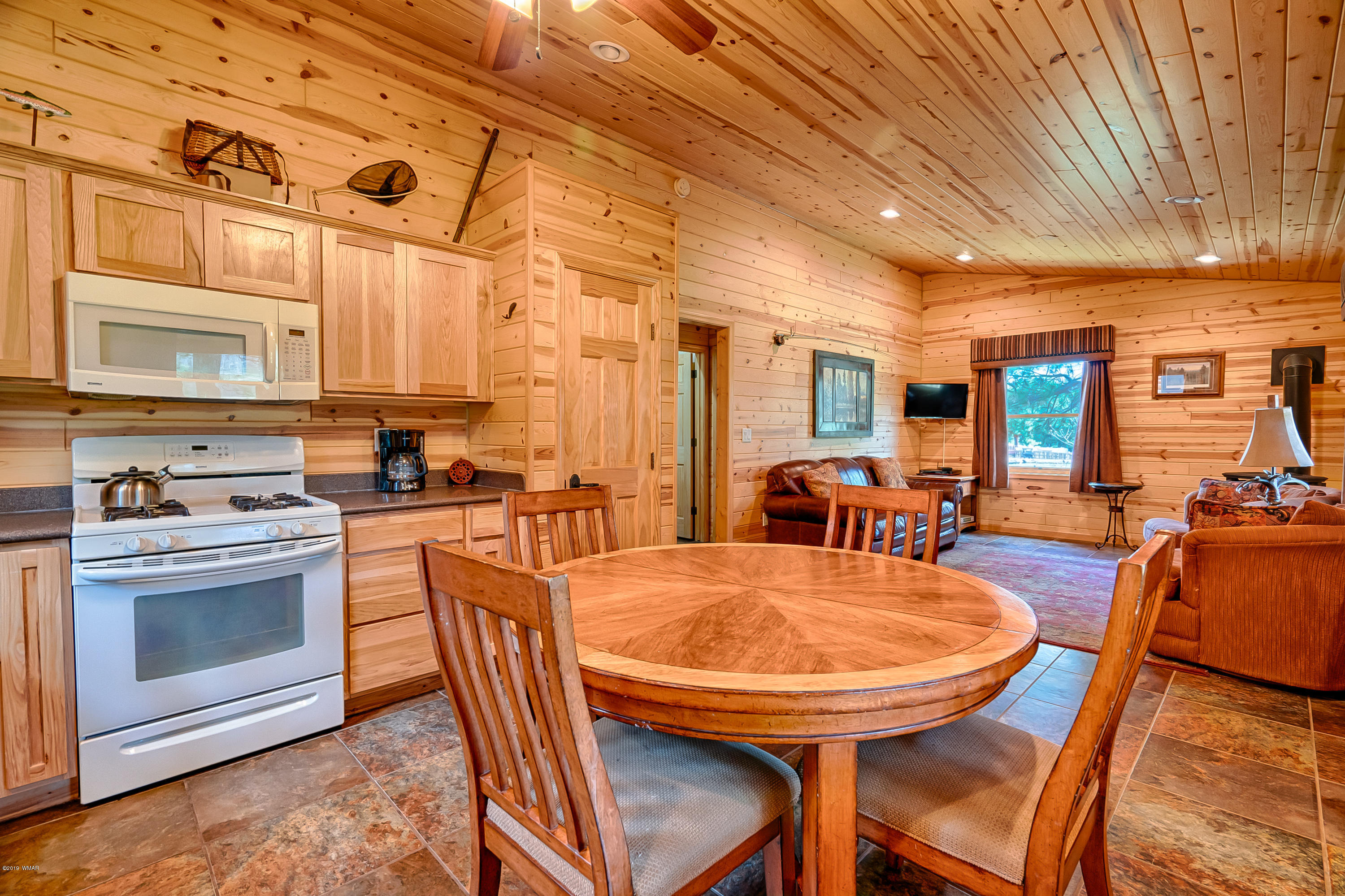 1120 Main, Unit 108 Greer, AZ 85927 - Photo 5 of 35 a kitchen with stainless steel appliances granite countertop a stove top oven a sink a dining table and chairs with wooden floor