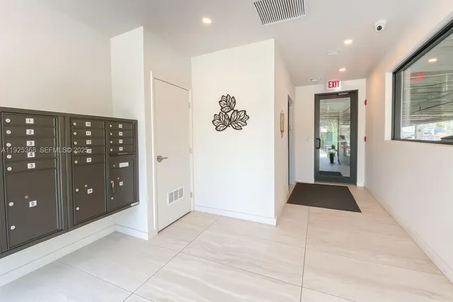 a view of an empty room with wooden floor and windows