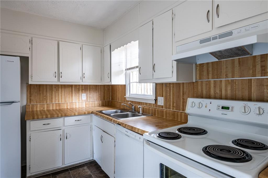 a kitchen with a stove a sink and cabinets
