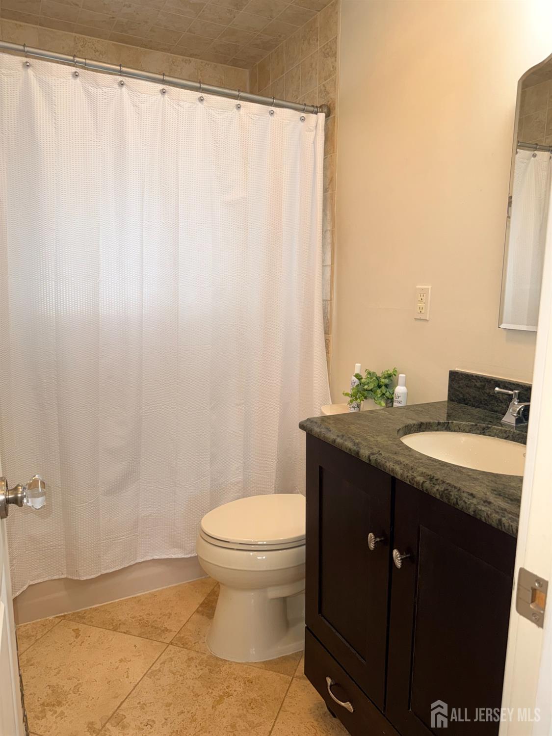27 Rector Avenue Woodbridge, NJ 07095 - Photo 17 of 29 a bathroom with a granite countertop sink and a mirror