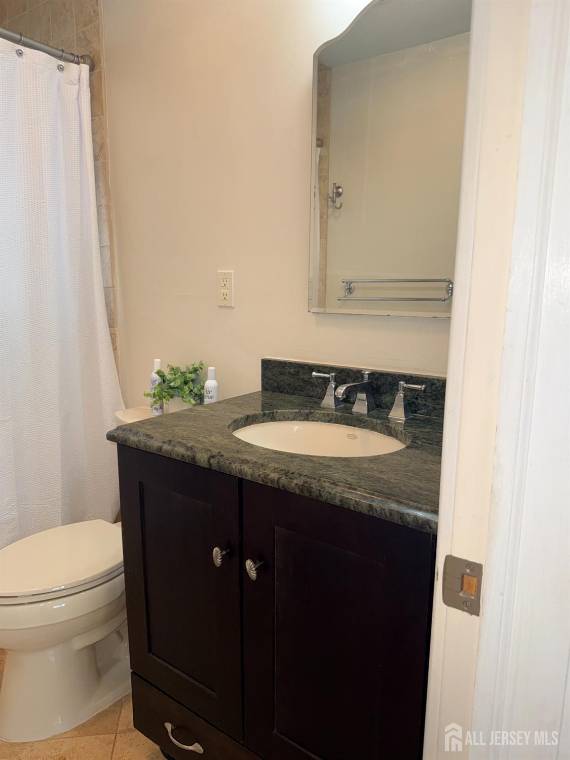 27 Rector Avenue Woodbridge, NJ 07095 - Photo 18 of 29 a bathroom with a granite countertop sink and a mirror