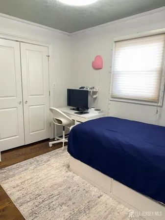 a spacious bedroom with a bed and a flat screen tv