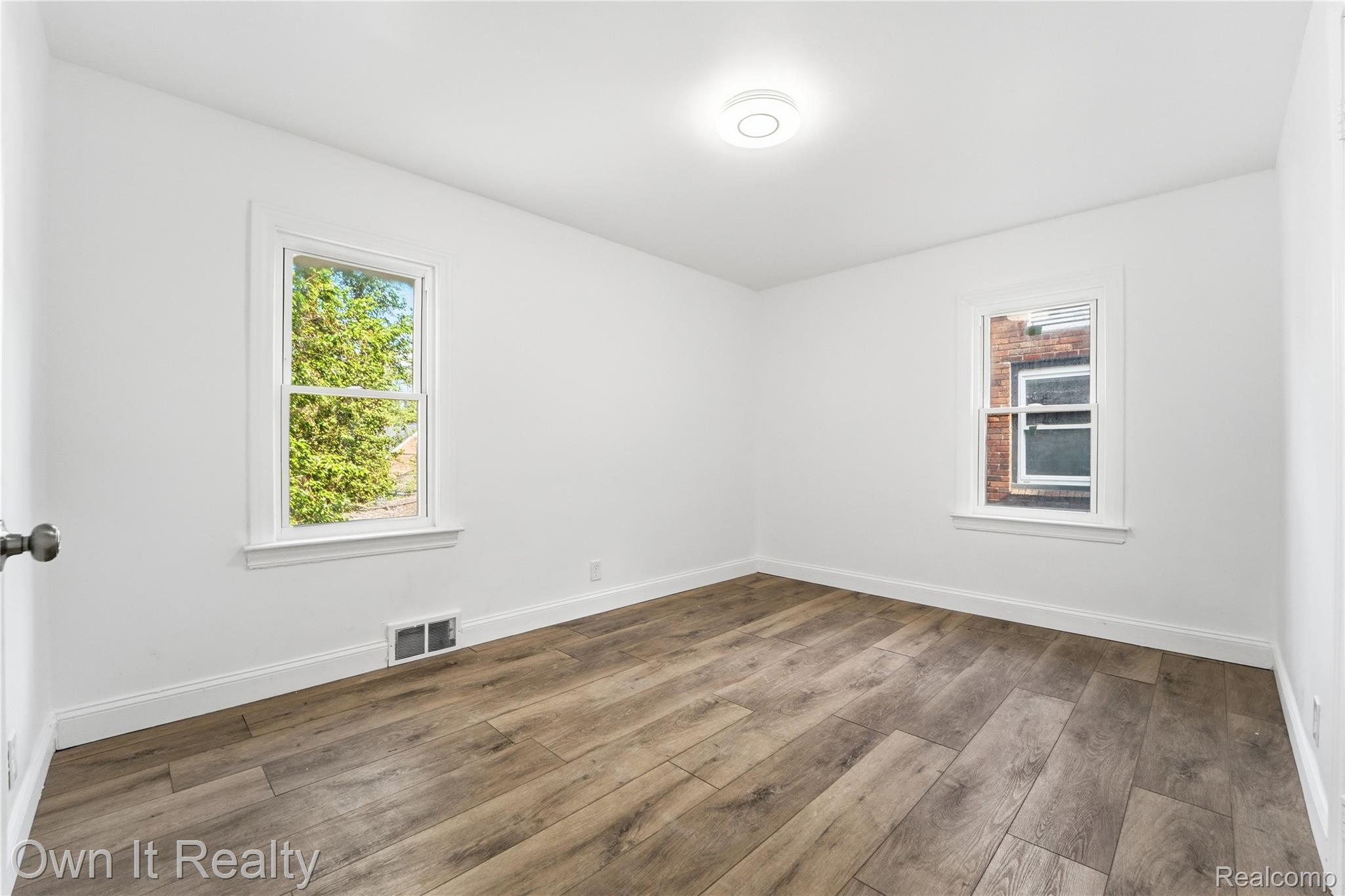 17351 Appoline Street Detroit, MI 48235 - Photo 23 of 34 Bright interior space featuring wood-finish flooring, white baseboards, and two double-hung windows
