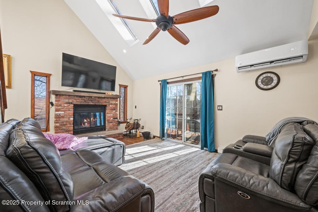 3110 Cherry Ridge Road Bushkill, PA 18324 - Photo 15 of 61 a living room with furniture a flat screen tv and a fireplace